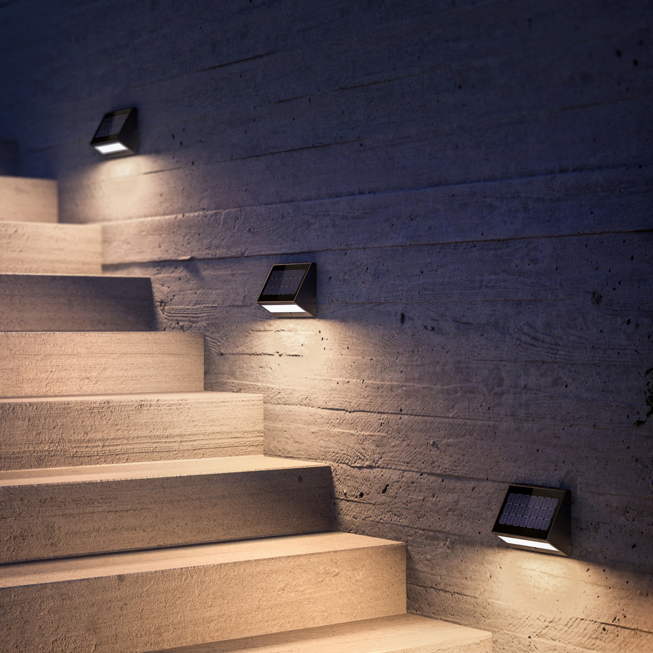 Stairway with wall-mounted lights on a textured wall at night.